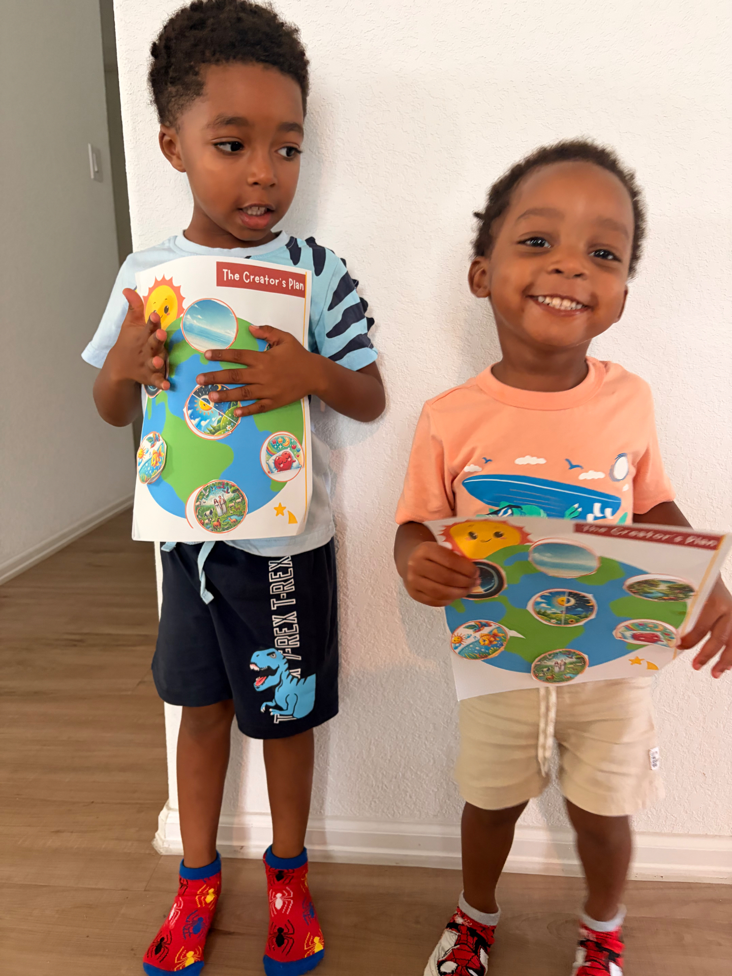 Two preschool students proudly holding their finished Creator's Plan Bible craft